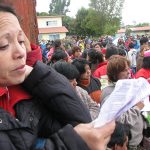 Devota siguiendo las canciones de la misa celebrada a las 12 hrs. frente al templo.